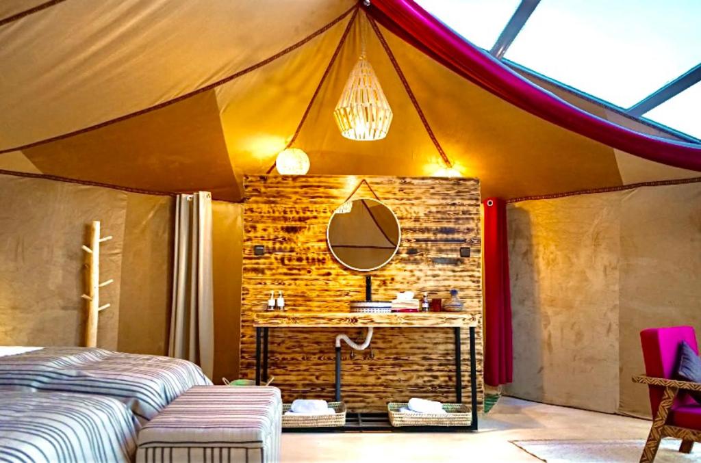 a room with a tent with a mirror and a table at Sky View Camp in Merzouga