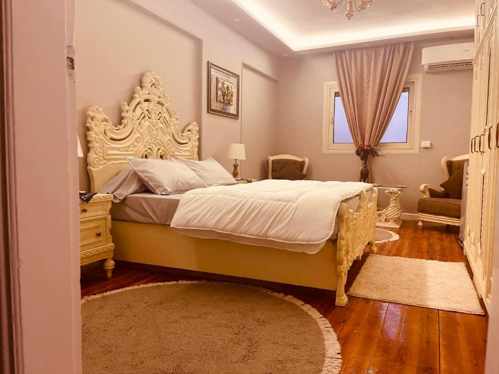 a bedroom with a large bed with a large headboard at WB Lounge - Mohandessin Apartment in Cairo