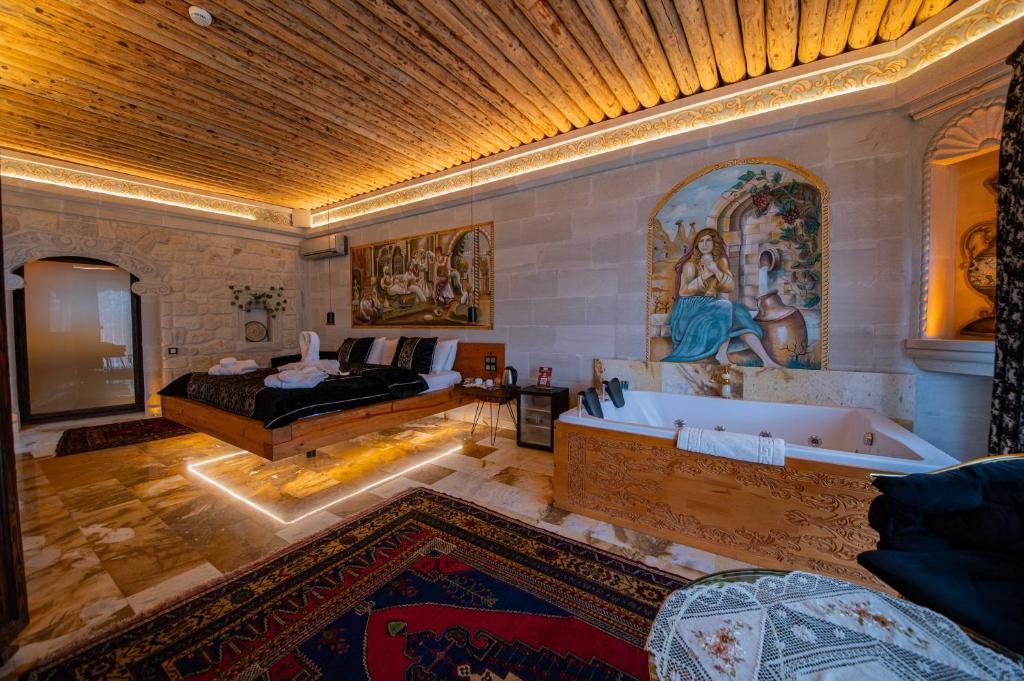 - une chambre avec un lit et une baignoire dans l'établissement Safran Cave Hotel, à Gorëme