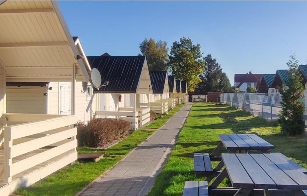 a row of houses with picnic tables in the grass at Ada.Vacations in Ustronie Morskie