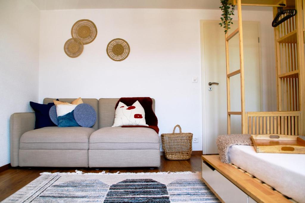 sala de estar con sofá y almohadas en Geräumige und stylische Wohnung mit Weitsicht, en Huttwil
