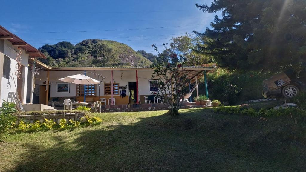 ein Haus mit einem Tisch und einem Sonnenschirm im Hof in der Unterkunft Finca Campestre Villa Gladys in Guatapé