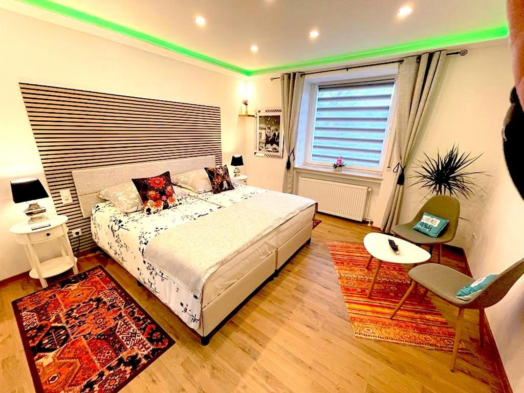 a bedroom with a large bed and a green lighting at Hotel Uthoff in Bissendorf