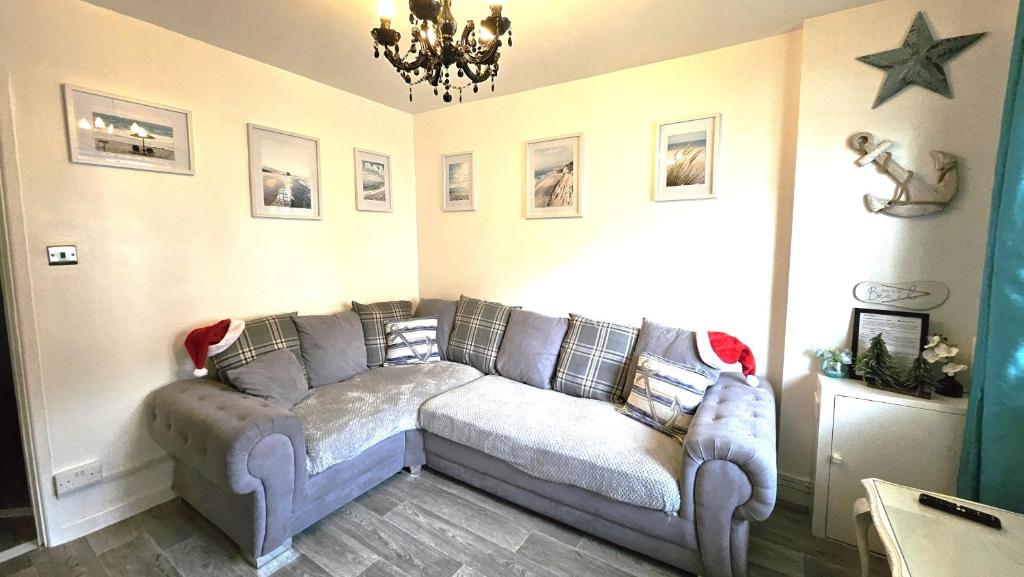 ein Wohnzimmer mit einem grauen Sofa in einem Zimmer in der Unterkunft Eastney Escape in Portsmouth