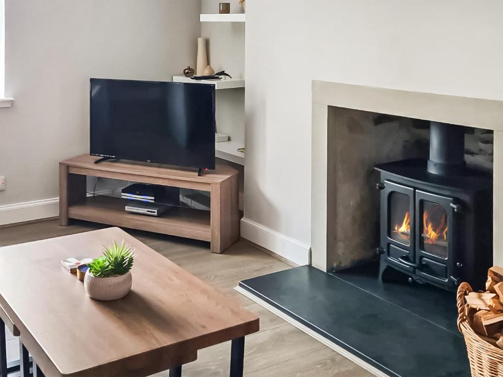 a living room with a fireplace and a television at The Shore in Fortrose