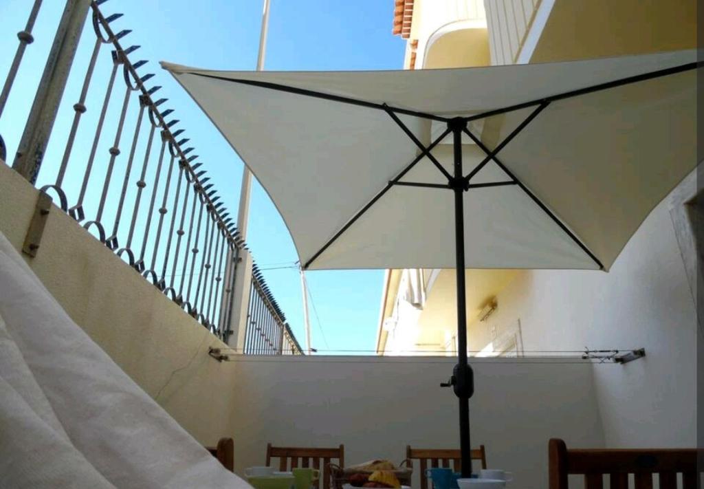 un parasol blanc assis sur une table dans un bâtiment dans l'établissement Cozy Beach House, à Santa Cruz