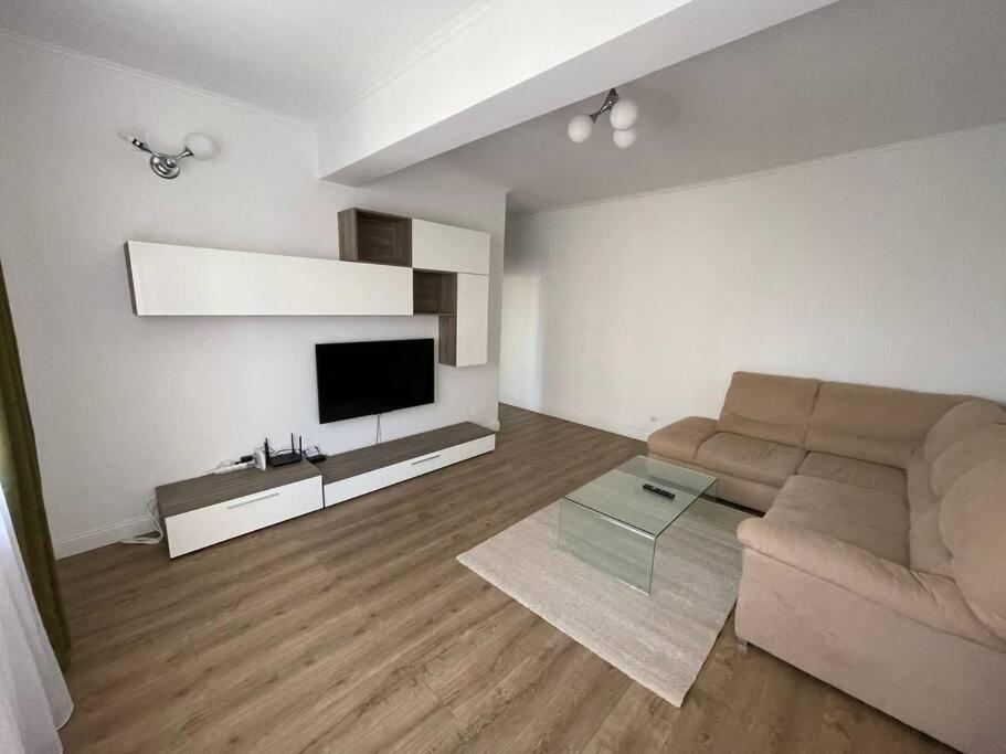 uma sala de estar com um sofá e uma televisão de ecrã plano em Apartament de lux Pitesti centru em Piteşti