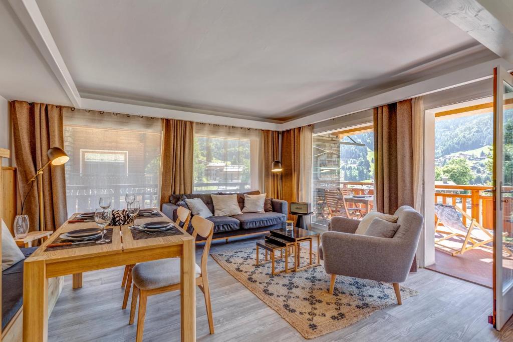 uma sala de estar com uma mesa e um sofá em Les Chalets de La Clusaz - Appartement le Yeti em La Clusaz