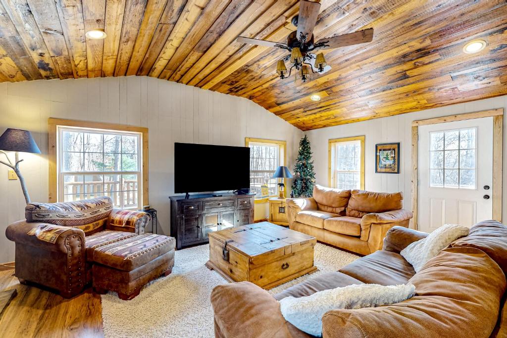sala de estar con sofás y TV de pantalla plana. en Pine Woods Cabin en McHenry