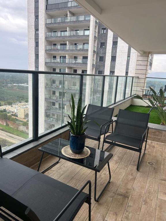 a balcony with chairs and a potted plant on it at A modern apartment in Acre in ‘Akko