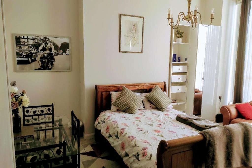 1 dormitorio con cama y lámpara de araña en Modern Studio Apartment, en Londres