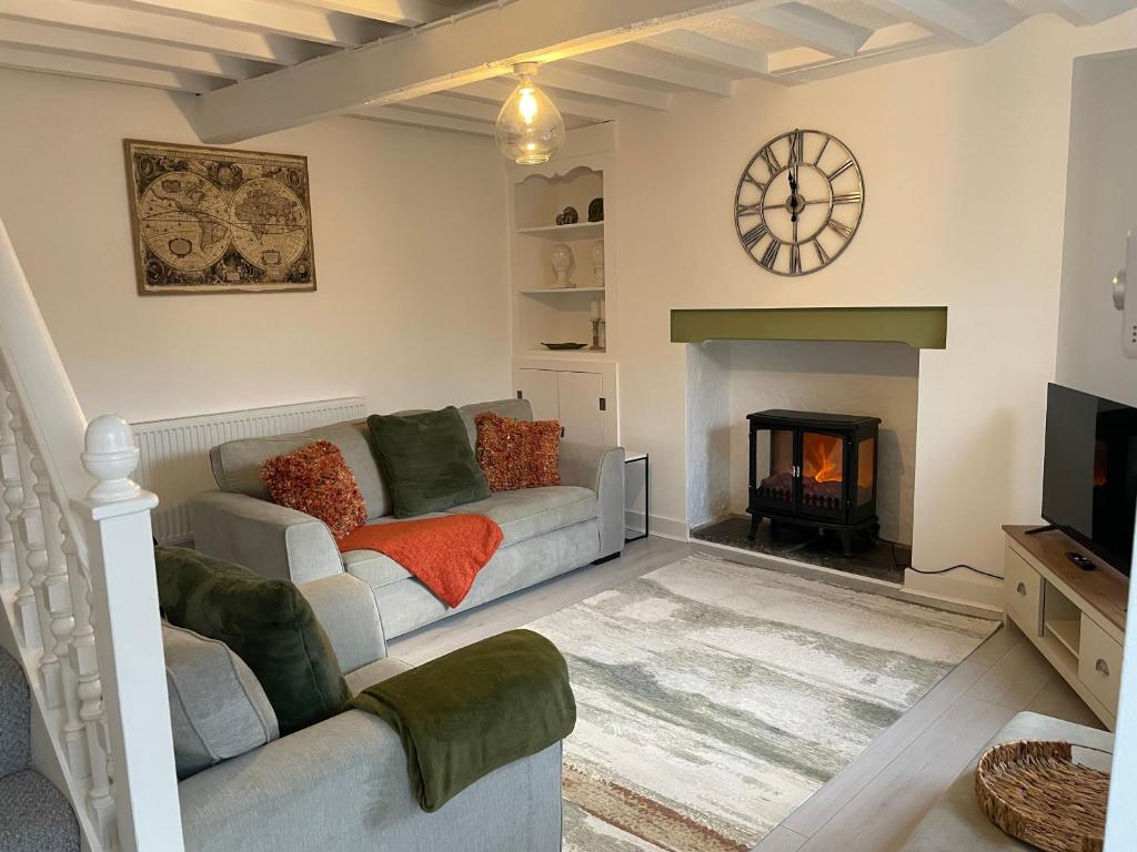 a living room with a couch and a fireplace at Castle Keep - Traditional Welsh Cottage in Llandudno Junction