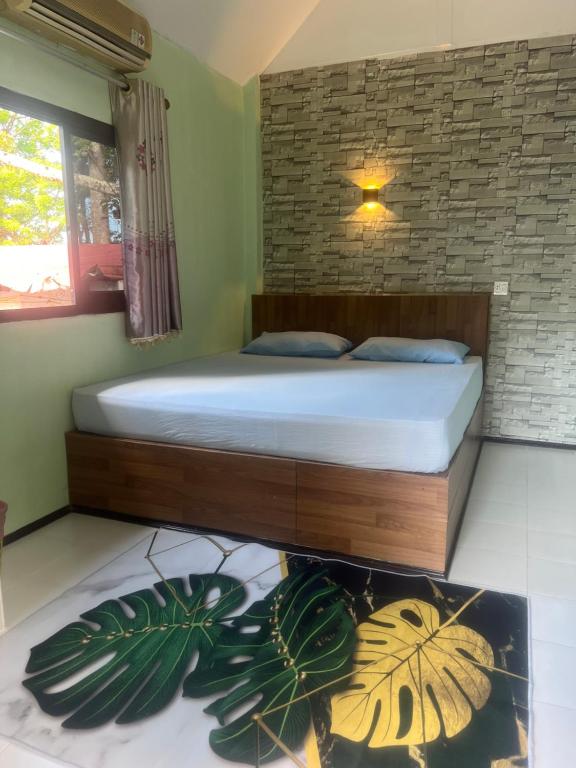 a bedroom with a bed and a plant at cher lonely beach resort Koh chang in Ko Chang