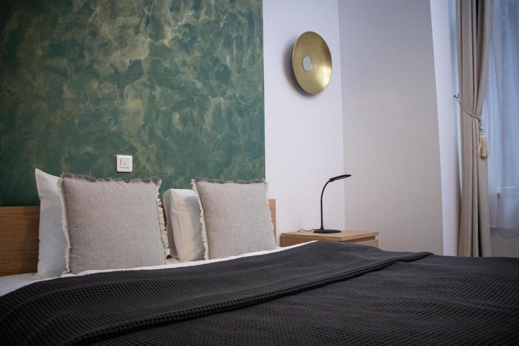 - une chambre dotée d'un lit avec un mur vert dans l'établissement House4You - Bălcescu 26, à Bucarest