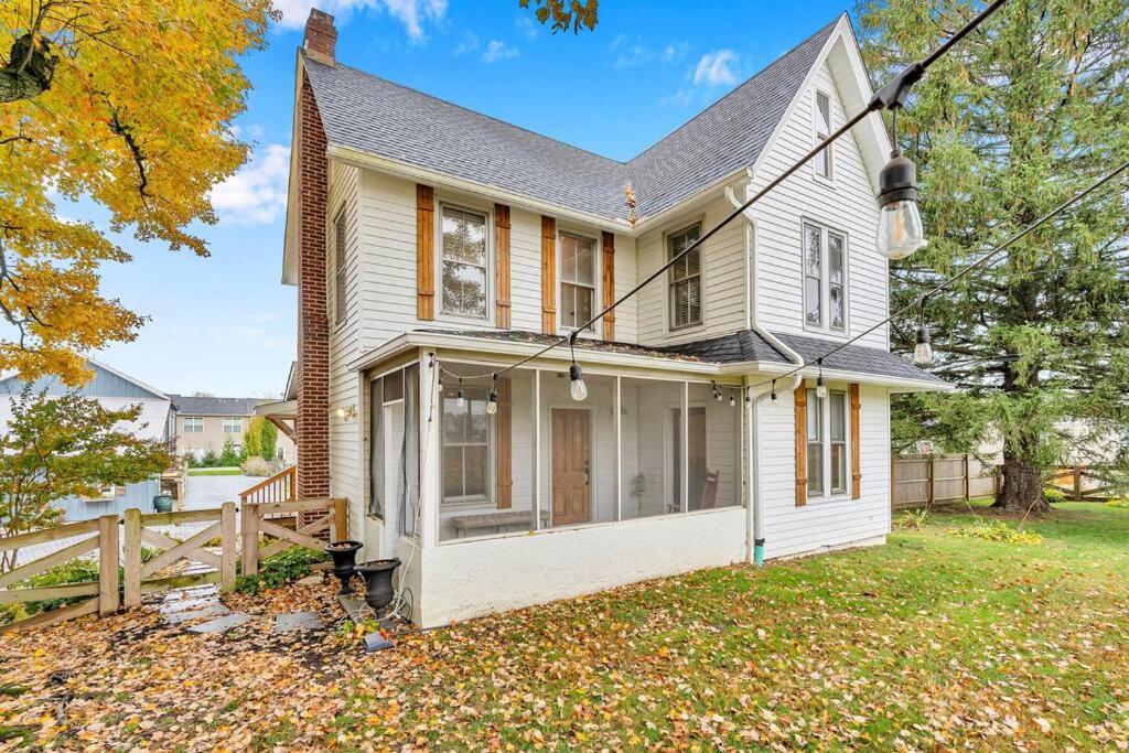 uma casa branca com um alpendre e uma cerca em Underground Railroad 3 Bedroom Farmhouse em Kennett Square