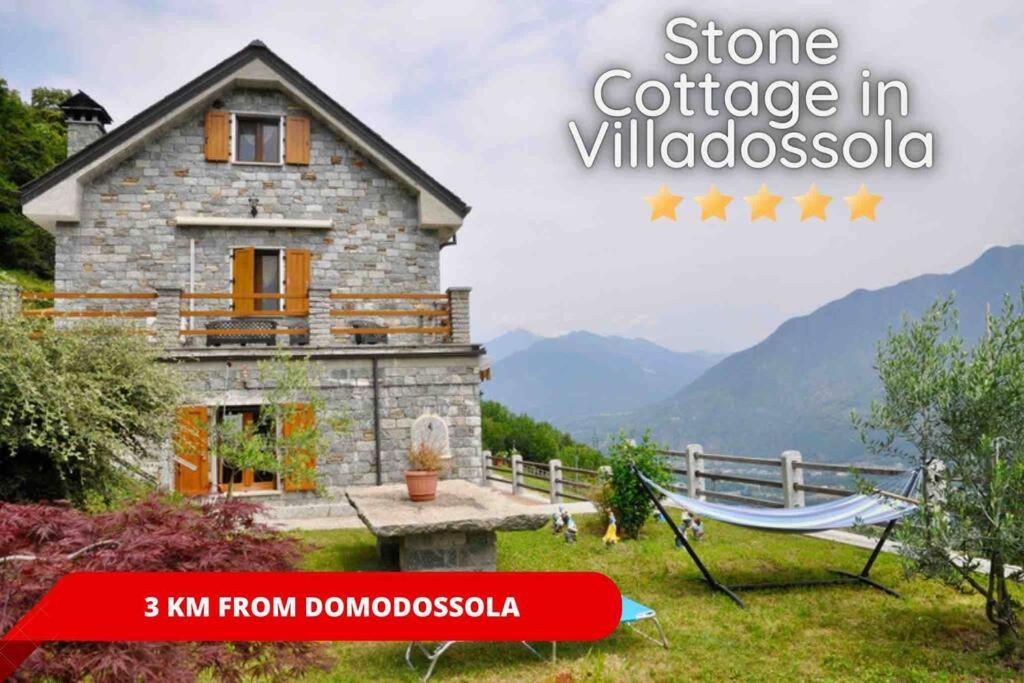 een stenen huisje in villosa met een hangmat ervoor bij Vista da Sogno, Casa di Montagna per il Tuo Relax in Villadossola