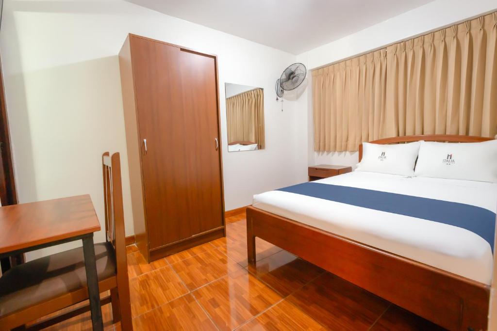 a bedroom with a bed and a table and a desk at Hotel Italia I in Chiclayo