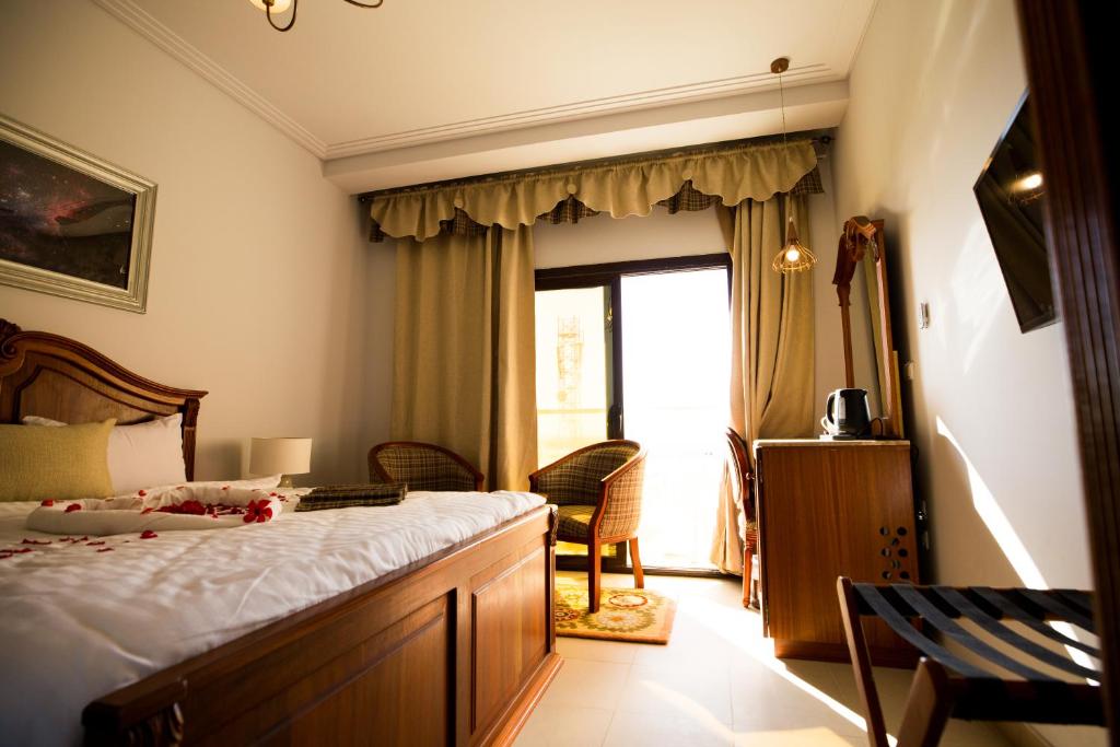a hotel room with a bed and a window at Holy Family Hotel in Jabal aţ Ţayr