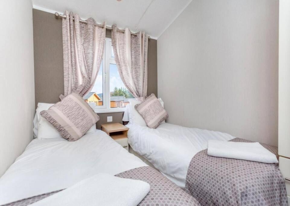 2 camas en una habitación pequeña con ventana en Scottish retreat en Banchory