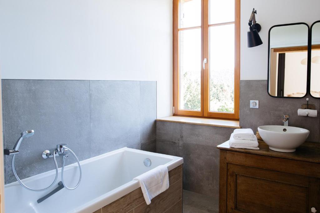 ein Badezimmer mit einer Badewanne und einem Waschbecken in der Unterkunft Des sapins aux étoiles in Pierre-Percée