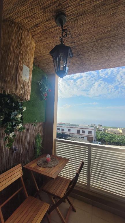 patio con mesa, sillas y ventana en Discover the north of the island of Tenerife, en La Laguna