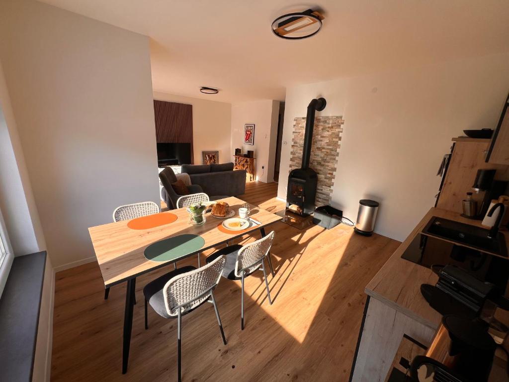 uma sala de estar com uma mesa e cadeiras e um fogão em Ferienwohnung ImZaro: Erdgeschoss, 2 Schlafzimmer plus Schlafsofa, eigener Eingang, große Terrasse mit Garten! em Spittal an der Drau