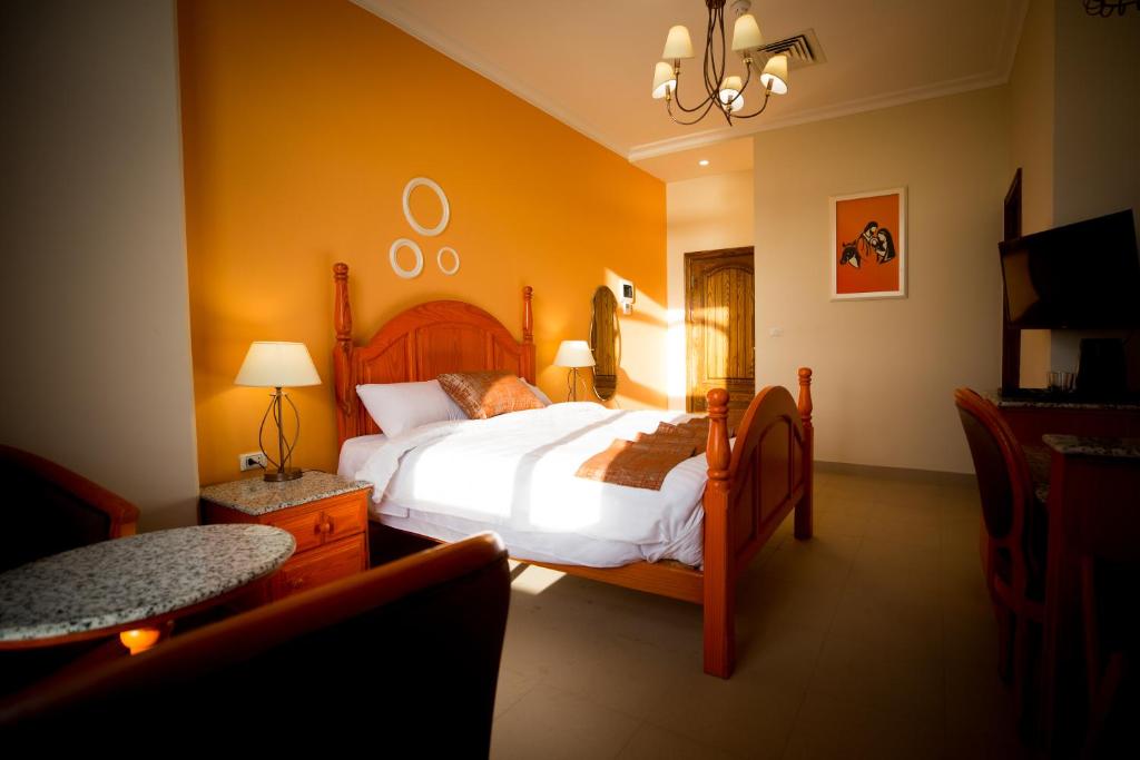 a bedroom with a bed in a room with yellow walls at Holy Family Hotel in Jabal aţ Ţayr