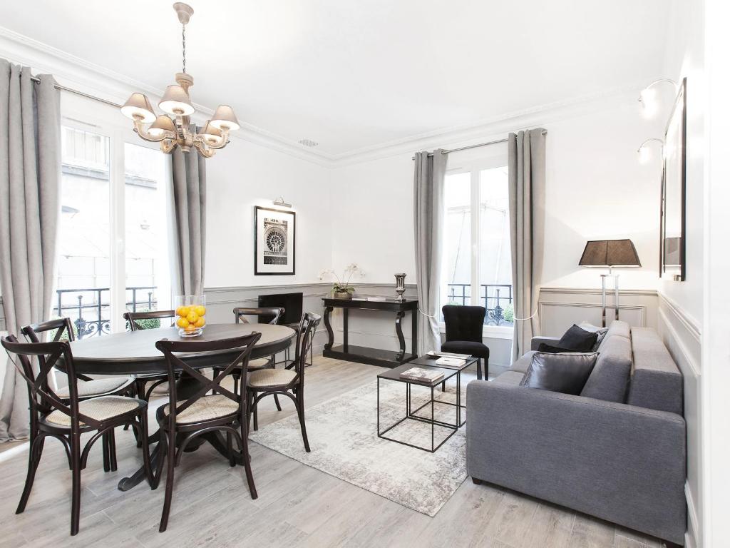 un salon avec une table et un canapé dans l'établissement LivinParis - Luxury 2 Bedrooms Grands-Boulevards I, à Paris