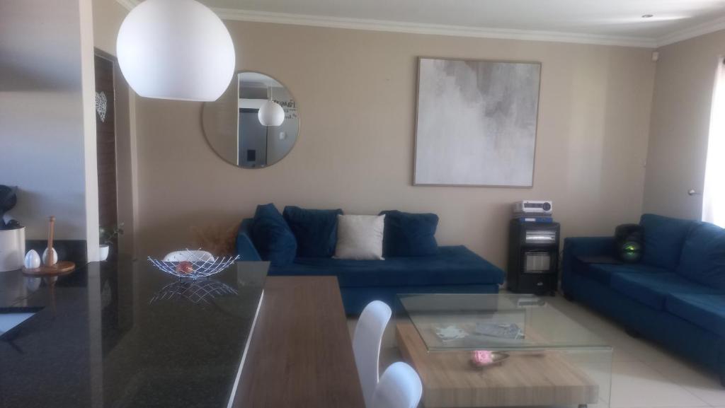sala de estar con sofá azul y mesa de cristal en 2 bedroom morden apartment, en Fairview