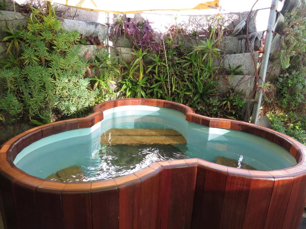 a small pool of water in a wooden tub at The green and red cabins in Ma'ale Gamla