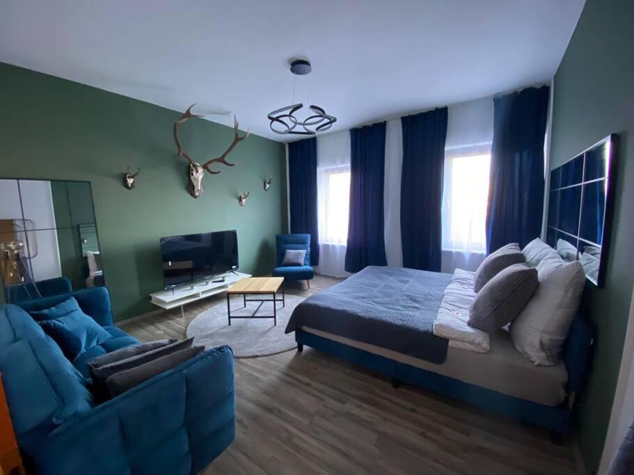um quarto com uma cama e um sofá azul em 3 Zimmer Apartment mitten in Altstadt - Koblenz em Koblenz