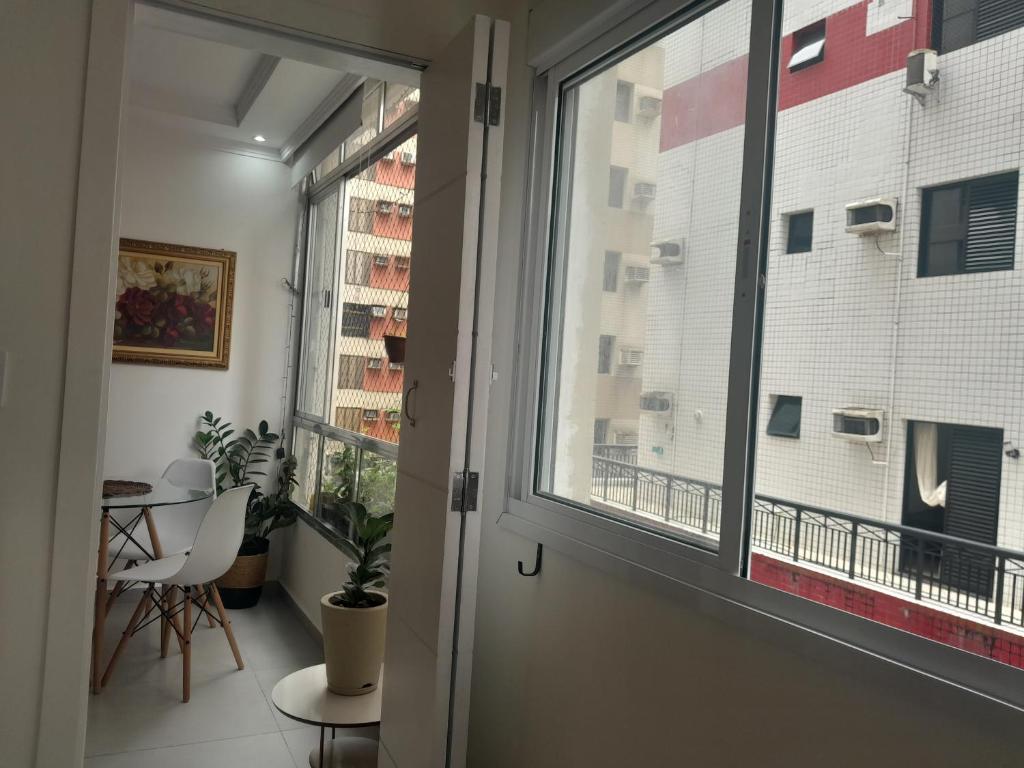 a room with a window and a table and a table at Beira-mar in Santos