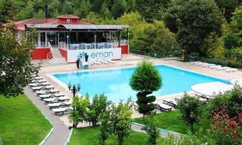 a large swimming pool with chairs and a building at EMAN TERMAL HOTEL in Ilıcalı