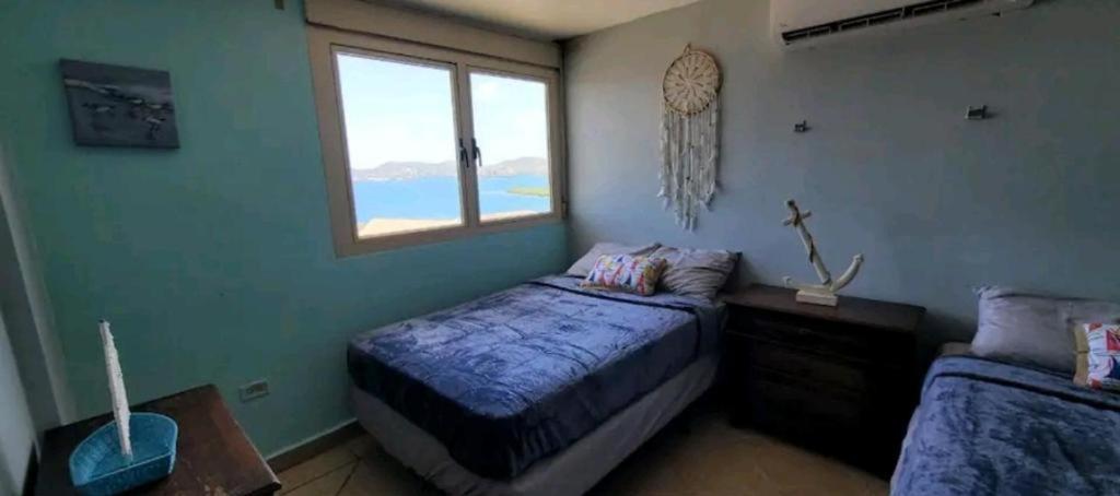 a bedroom with a bed and a window at Costa Bonita Apt in Culebra