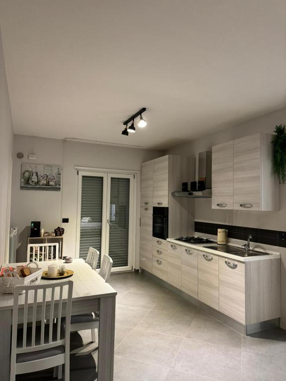 a kitchen with white cabinets and a table and chairs at DIMA'S HOUSE in Volla