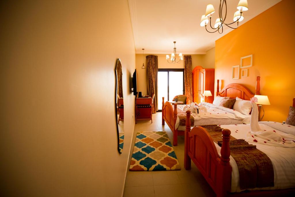 a bedroom with two beds and a living room at Holy Family Hotel in Jabal aţ Ţayr