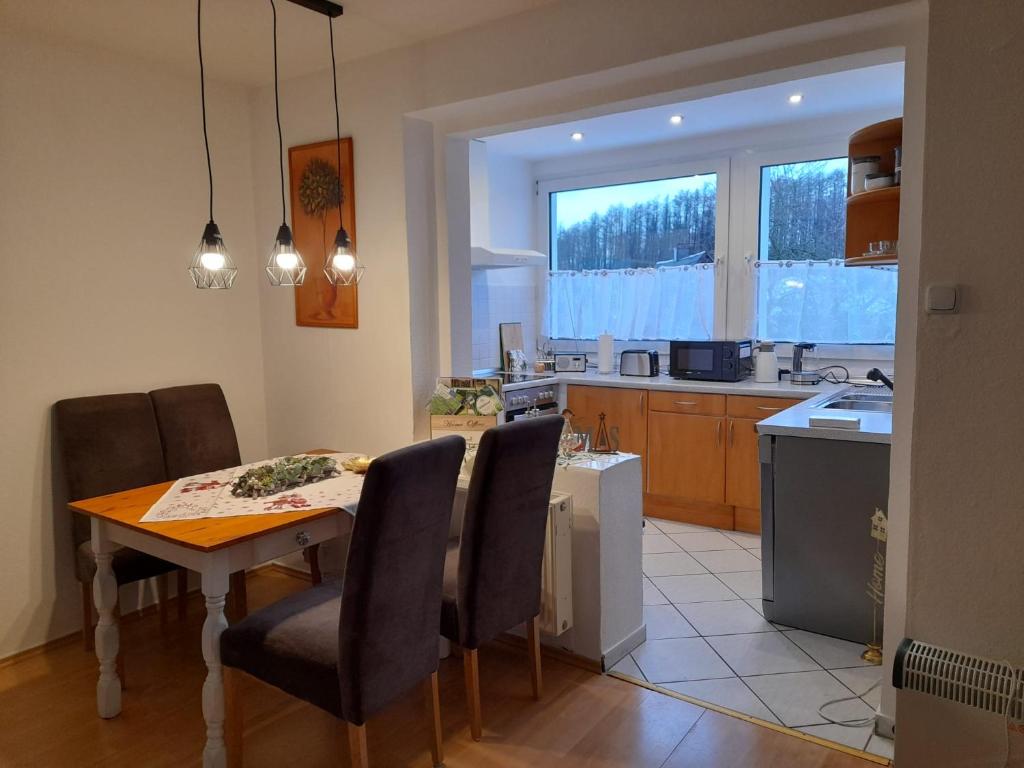 - une cuisine et une salle à manger avec une table et des chaises dans l'établissement Ferienwohnung Prinz, à Meinerzhagen