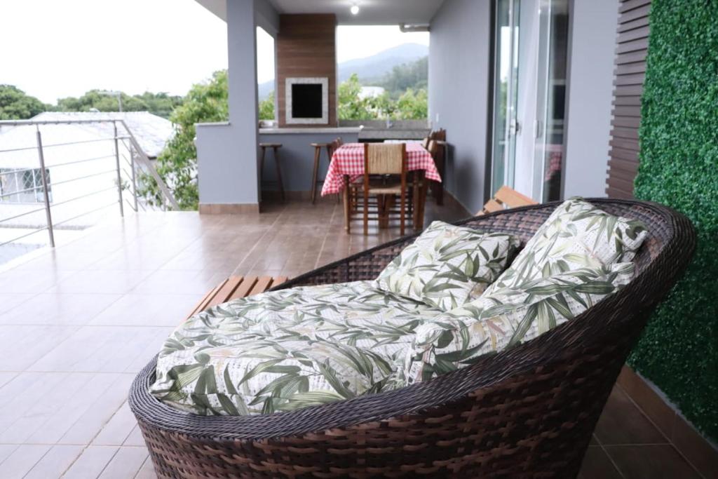 a wicker chair sitting on the balcony of a house at Cobertura Enseada de Zimbros in Bombinhas