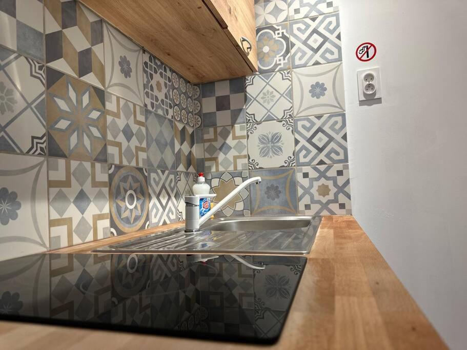 a kitchen counter with a sink and a bottle of soap at Logement Entier au Centre Ville in Évreux