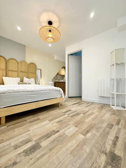 a bedroom with a large bed and wooden floors at Logement Entier au Centre Ville in Évreux