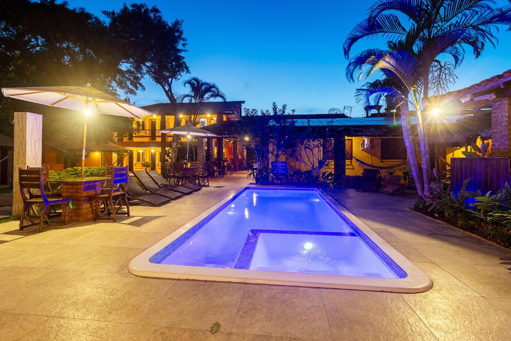 a swimming pool in the middle of a patio at night at Pousada Cavalo Marinho in Arraial d'Ajuda