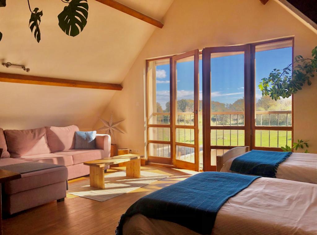 a living room with a couch and a large window at Le Chêne Doux in Glandon