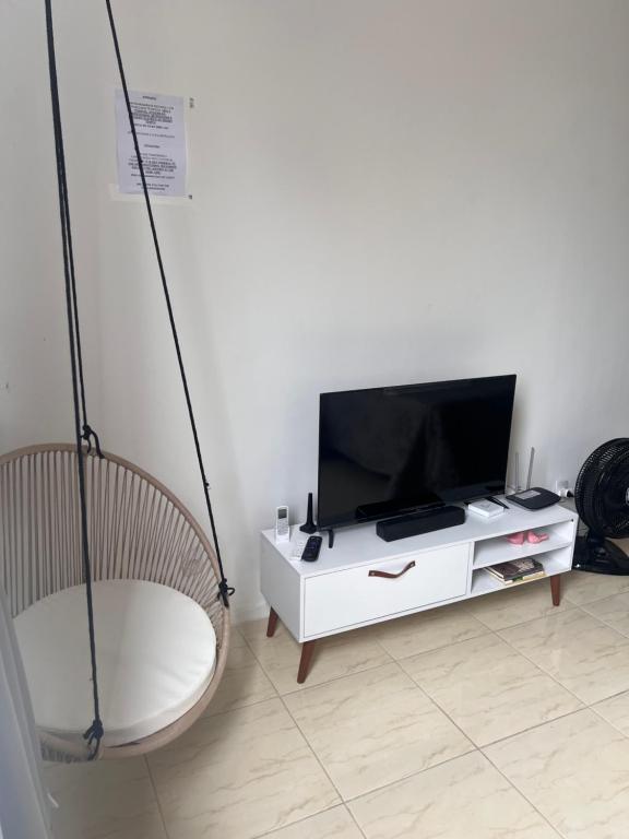 a living room with a chair and a flat screen tv at Loft no coração da Lapa in Rio de Janeiro