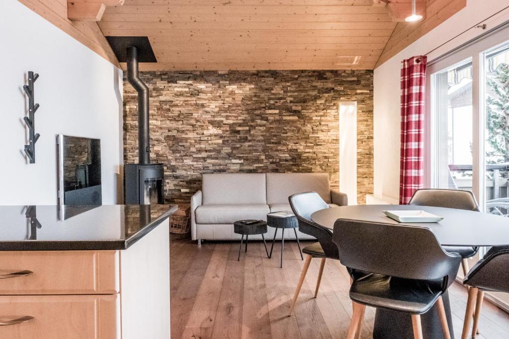 a kitchen and living room with a table and chairs at Chalet Eiger View - GRIWA RENT in Grindelwald