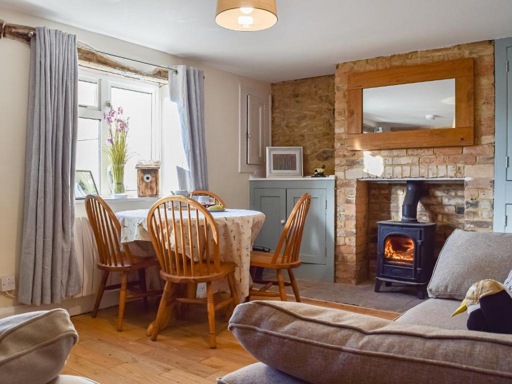 uma sala de estar com uma mesa e uma lareira em Willow Cottage 