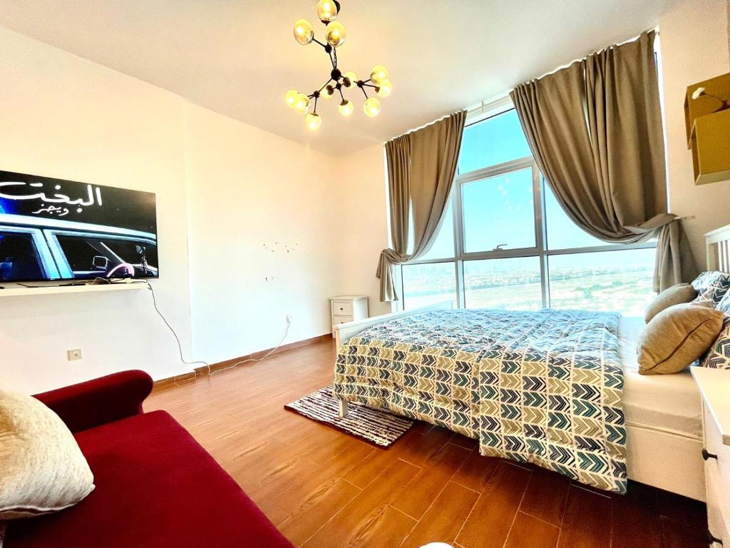 a bedroom with a bed and a large window at Studio apartment in Jumeriah village triangle in Dubai
