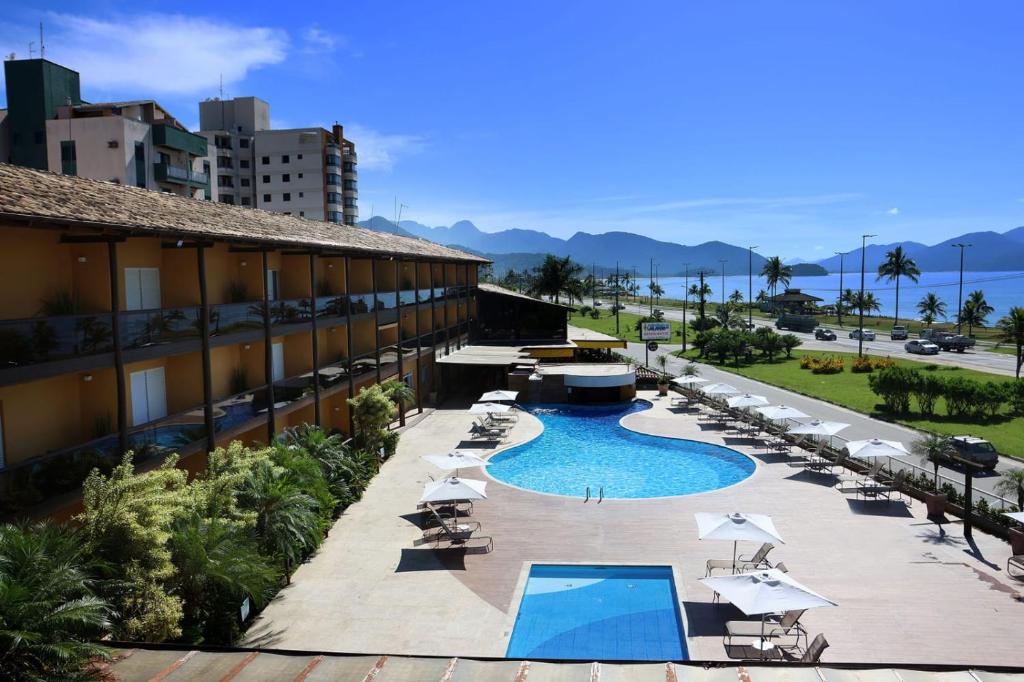 einen Blick über das Resort mit Pool und Stühlen in der Unterkunft Hotel Costa Norte Massaguaçu in Caraguatatuba