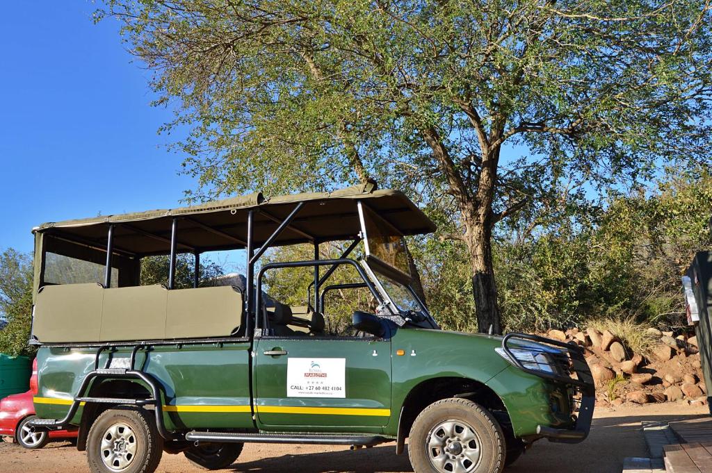 a green jeep parked in a parking lot at Royal Marlothi Kruger Safari Lodge and Spa in Marloth Park