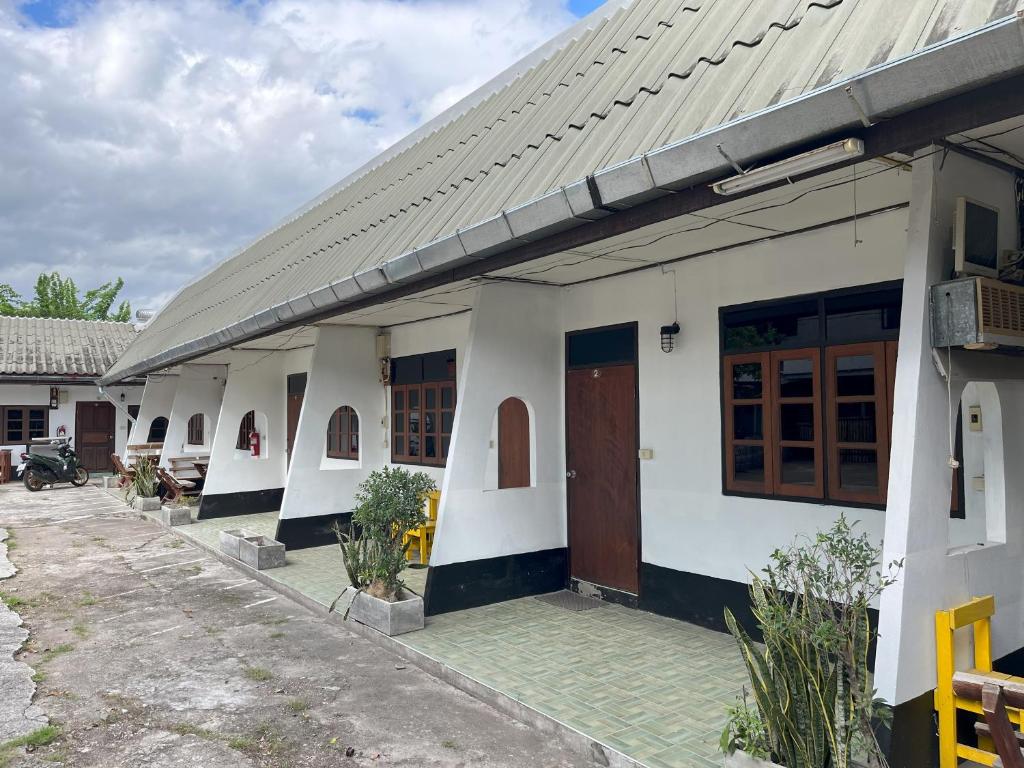 a white building with brown doors on it at Revolution Pai In Town in Pai