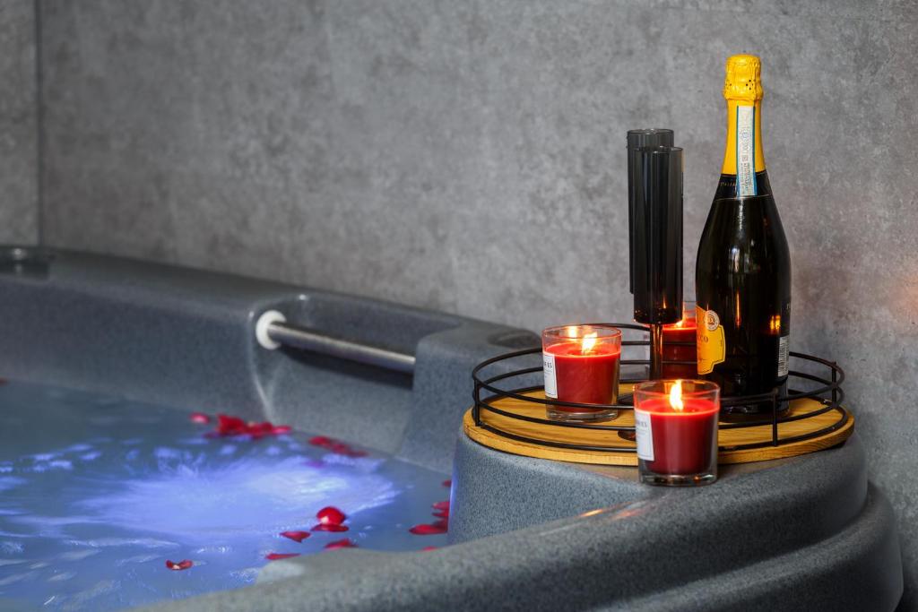 a bottle of wine and candles in a bath tub at Riverside studio with Jacuzzi! in Sheffield